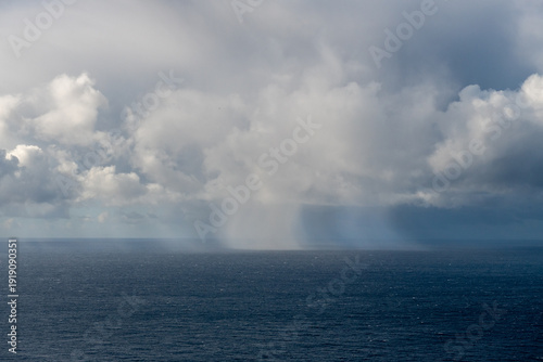 punktowe opady deszczu nad ciemnym oceanem
