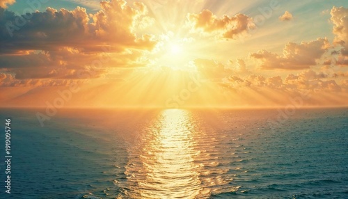 Bright sun setting on the horizon over a calm ocean. Beautiful sky with golden clouds. Nature and summer travel concept.