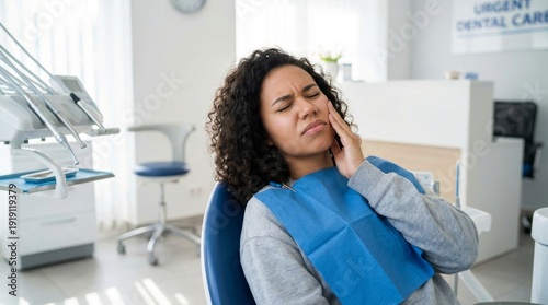 Young multiethnic woman suffering from toothache, Young Woman Suffering from Severe Toothache Holding Cheek in Dental Clinic Represents Dental Emergency and Oral Pain