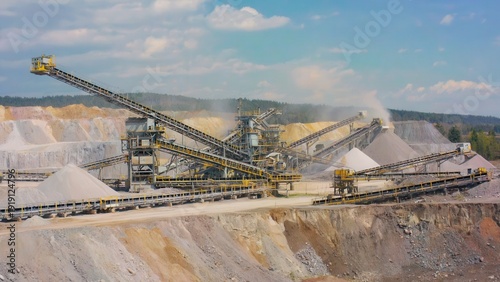 Large mineral processing plant with crushing and grinding machinery operating in quarry landscape