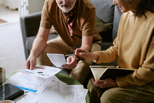 Canvas Print Senior Caucasian man and woman reviewing financial documents together at table,