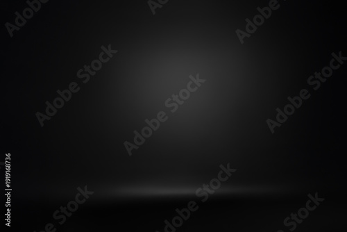 Professional black studio background with soft lighting gradient. This high-quality image features a seamless dark paper texture with a subtle spotlight effect in the center