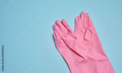 A pair of pink rubber gloves on a blue background