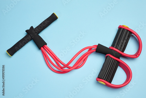 Bild auf Leinwand Red and black fitness expander, four elastic tubes, soft handles and foot rests