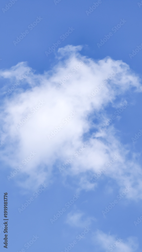 Obraz premium A tranquil and clear bright blue sky adorned with a single fluffy white cloud, evoking feelings of serenity and peacefulness on a beautiful day, offering a sense of openness and natural beauty