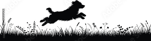 Black silhouette of dog jumping over grass and flowers