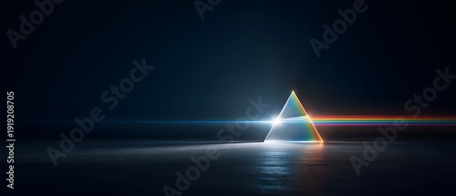 A triangular prism refracts white light into a rainbow spectrum on a dark background