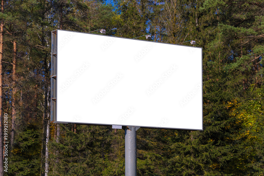 Fototapeta premium Advertising billboard along the road in the city on a sunny day. Background for design.