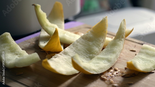 Photos Peel of yellow melon on wooden cutting board, leftover fruit remains, seeds scat