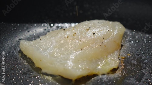 Frying white fish fillets. Frying hake fillets in a hot pan Detailed image of seasoned cod being prepared in comfortable kitchen setting. Intimate shot capturing aromatic seasoned. Selective focus
