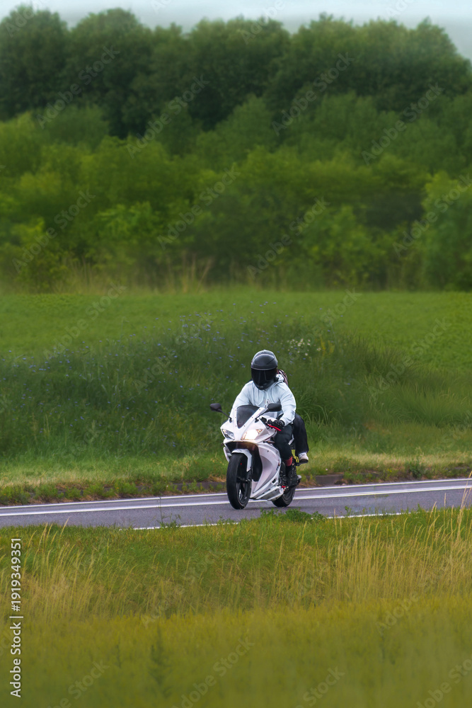 Obraz premium Motorcycle journey along a scenic grass landscape