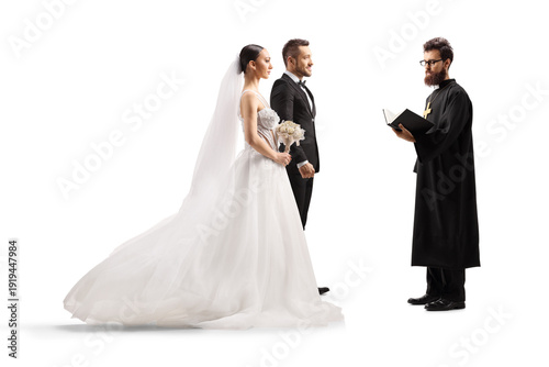 Φωτογραφία Bride and groom standing in front of a priest at a wedding ceremony