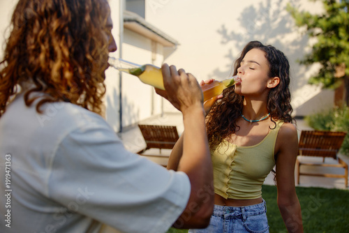 Photography Young couple drinking cold refreshing beverages during summer backyard party