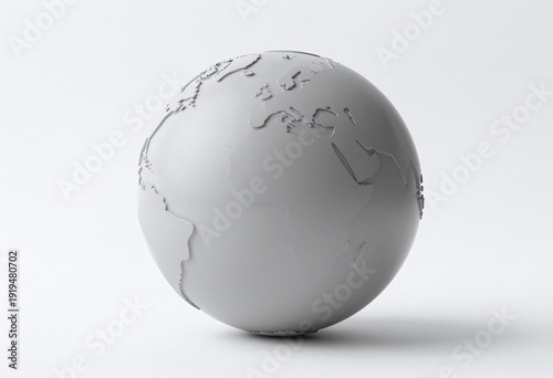 vast unblemished grey globe rests stark white background illuminated soft overhead light casts shadows