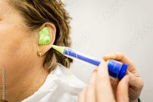 Obraz na płótnie Detail of a senior woman having custom-made earplugs fitted at a specialized ear clinic
