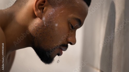 Man Washing Face with Water in Bathroom