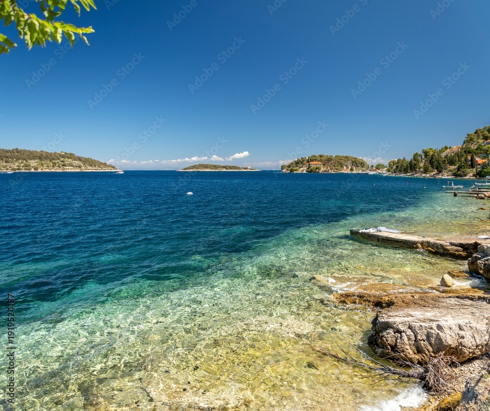 Obraz premium Croatia's island of Vis in Dalmatia. A view of the Adriatic Sea bay in the town of Vis. Summer weather and beautiful azure sea surrounded by nature.