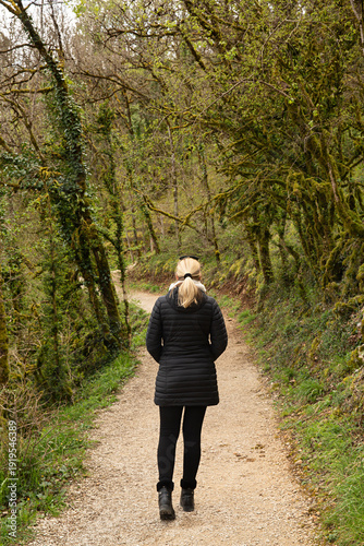 Fototapeta Mujer paseando por un bosque en invierno.