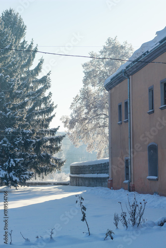 Historic orange building and snowy garden in a bright sunny winter morning