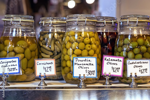 Fényképezés Assorted olive jars with handwritten price labels at market