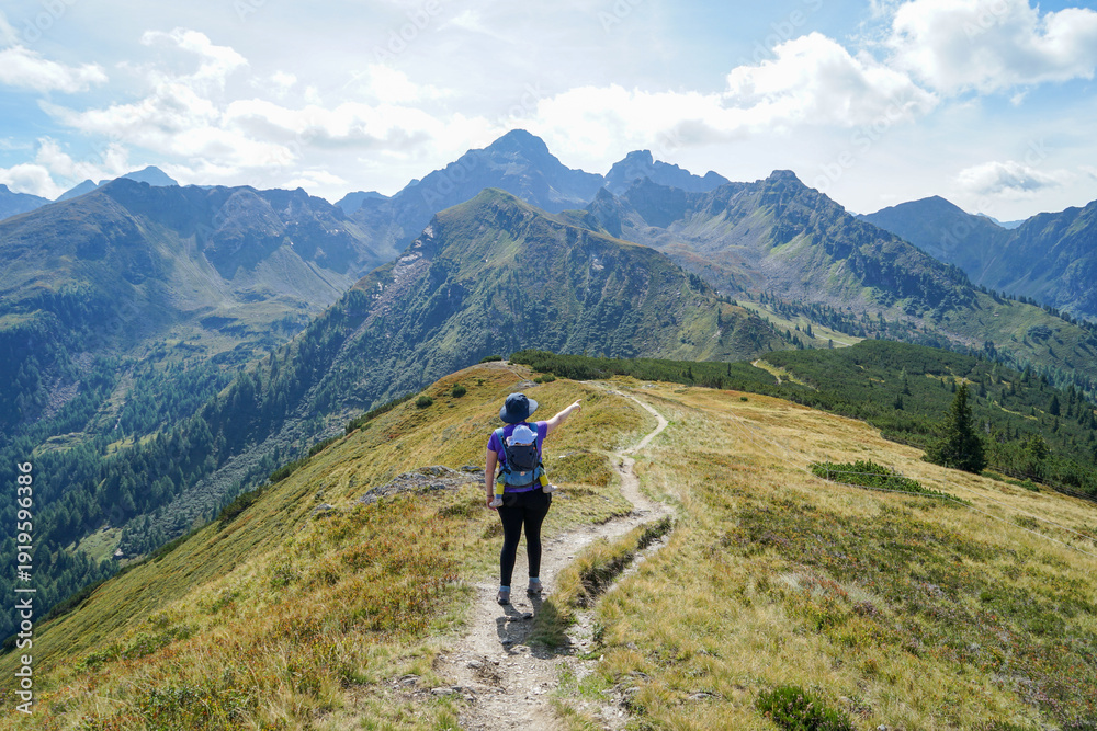 Obraz premium Young mother hiking at Hauser Kaibling with baby carrier and alpine mountain view