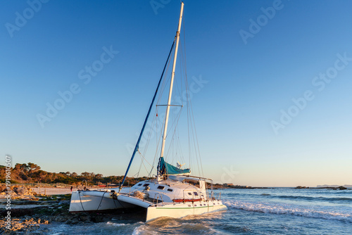 фотографія catamaran run aground on the coast due to a storm, Es Dolç beach, municipality o