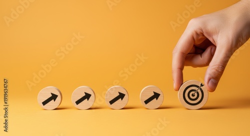 A hand selects a wooden block with a target symbol from a row of blocks with arrows, signifying goal achievement