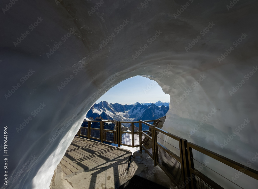 Fototapeta premium Breathtaking Aiguille du Midi ice tunnel exit hole for climbers and alpinists featuring panoramic view of snow covered French Alps mountain peaks from high altitude summit in Chamonix Mont Blanc area