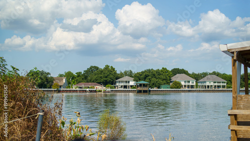 Bilde på lerret Residential houses on stilts along the waterfront under a cloudy blue sky in Louisiana USA