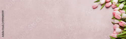 Beautiful tulips on pink table, top view. Banner design with space for text