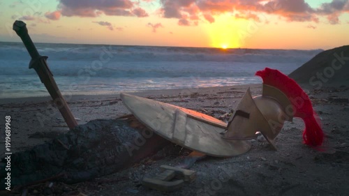 Wallpaper Mural an ancient battlefield at sunset, a Spartan sword, shield, and helmet on the ground Torontodigital.ca