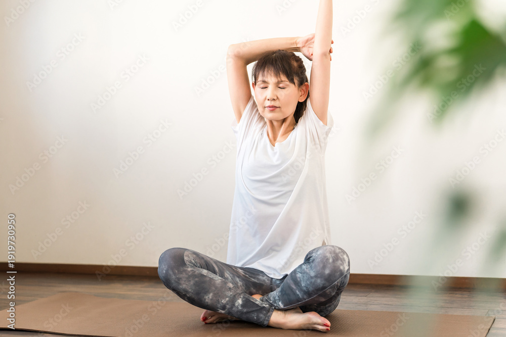 Ταπετσαρία A woman practicing yoga in a yoga studio or yoga class (instructor/yoga teacher)