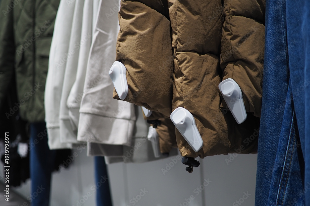 Φωτογραφία security tags on cloths on display in a retail store