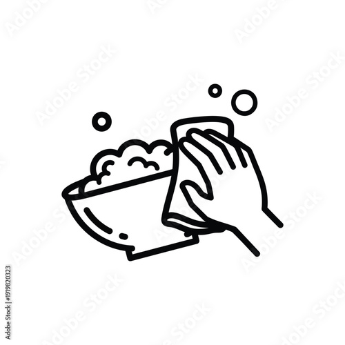 Hand washing dishes in a sink with soap and water from a close-up view