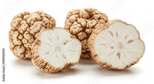 Close up of whole and sliced white truffles on a white background showcasing texture and interior