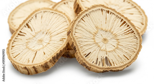 Sliced dried root vegetable possibly burdock or lotus root arranged on white background with visible texture and natural lighting