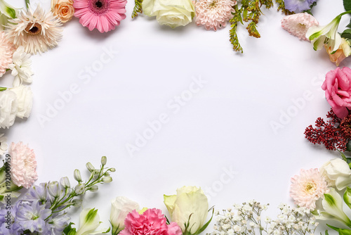 Frame made of different flowers on white background