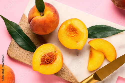 Canvastavla Cutting board with sweet ripe peaches and leaves on pink background
