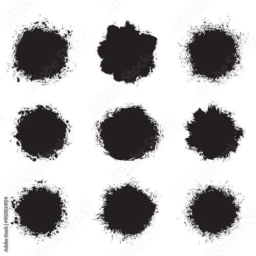 A collection of nine black inkblot spots on a white background