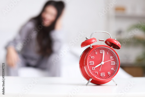 Red alarm clock on table ag...