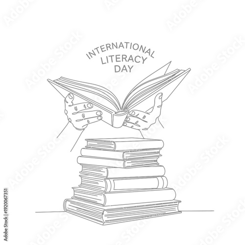 Hands holding an open book over a stack for International Literacy Day.