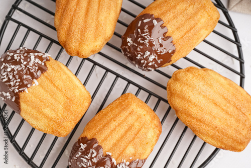 Fotografie Grid with delicious madeleines with chocolate cream and coconut flakes on white