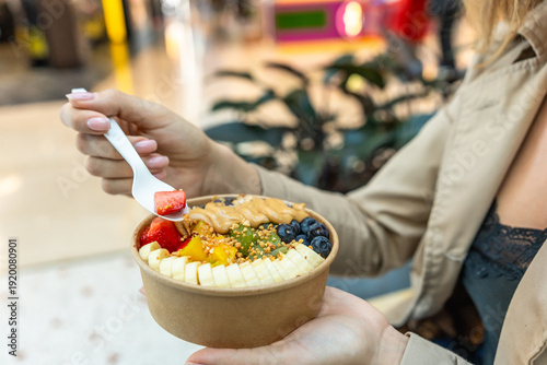 Woman enjoying a healthy acai fruit bowl outdoors