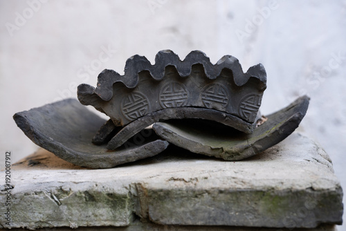 Valokuva Elément de jardin zen; sculpture de tuiles grises en forme de couronne posé sur