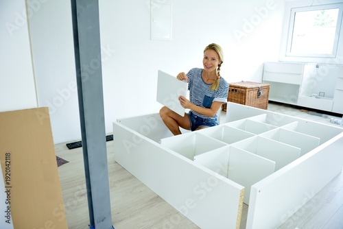 Woman assembling cabinet at home