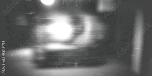 A blurry, grainy black and white photograph captures an abstract scene with a bright central light source