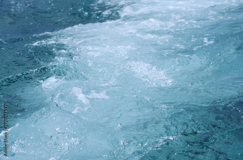 Churning sea foam and turquoise waves in the open ocean.