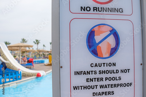 Quadro em tela Warning sign at a swimming pool area indicating no running and caution for infan