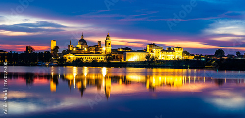 Panoramic evening view of Mantua, Lombardy, Italy; scenic twilight skyline view of the medieval town reflected in the lake waters