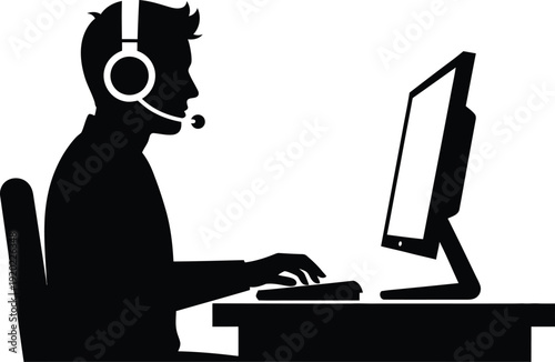 Silhouette of person with headset working on computer at desk